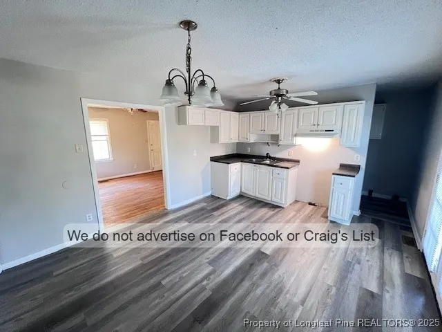 a kitchen with granite countertop a stove and wooden floor