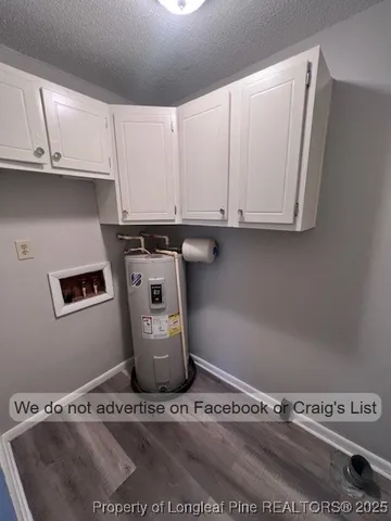 a view of water heater and cabinets