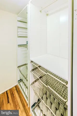 a view of a room with wooden floor and a ceiling fan