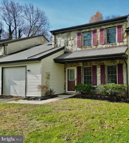 a front view of house with yard and trees around