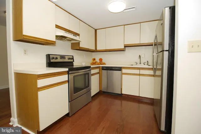 a kitchen with white cabinets stainless steel appliances and sink