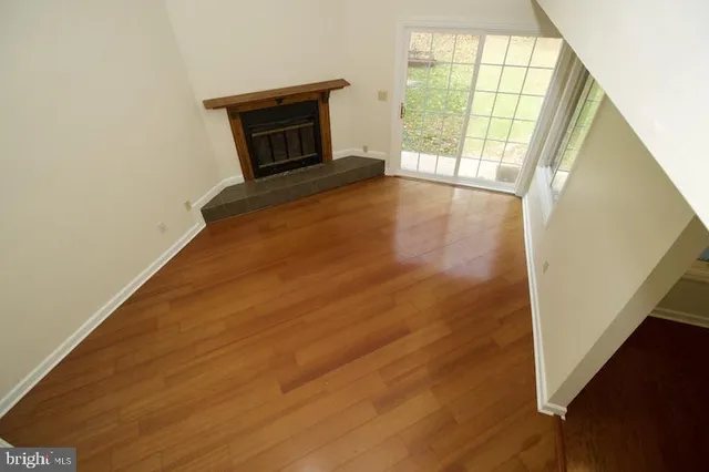 an empty room with a chandelier fan and a window