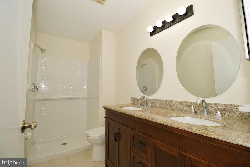 305 Pine Valley Road Dover, DE 19904 - Photo 24 of 37 a bathroom with a granite countertop toilet a sink and a mirror