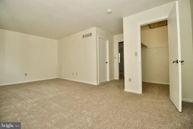 a view of an empty room with wooden floor and stairs