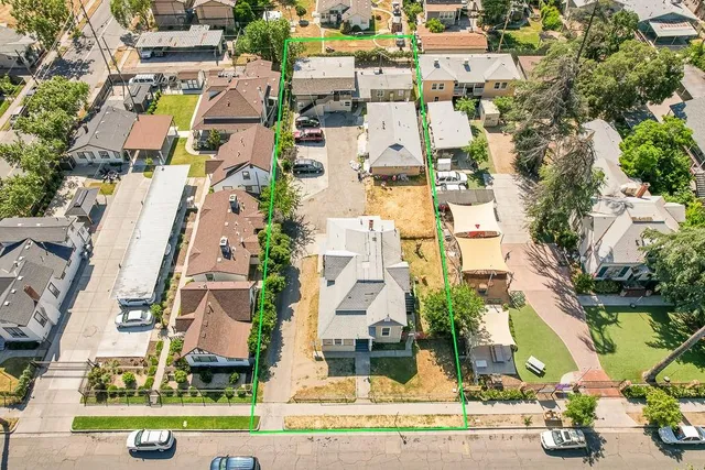 an aerial view of residential houses with outdoor space and parking