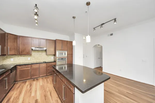 a kitchen with kitchen island a counter top space appliances and cabinets