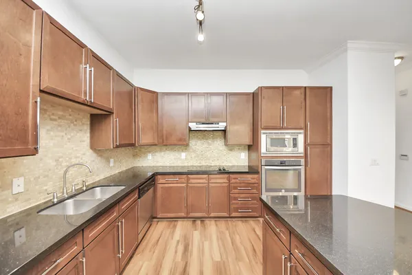 a kitchen with kitchen island granite countertop a sink stove and cabinets
