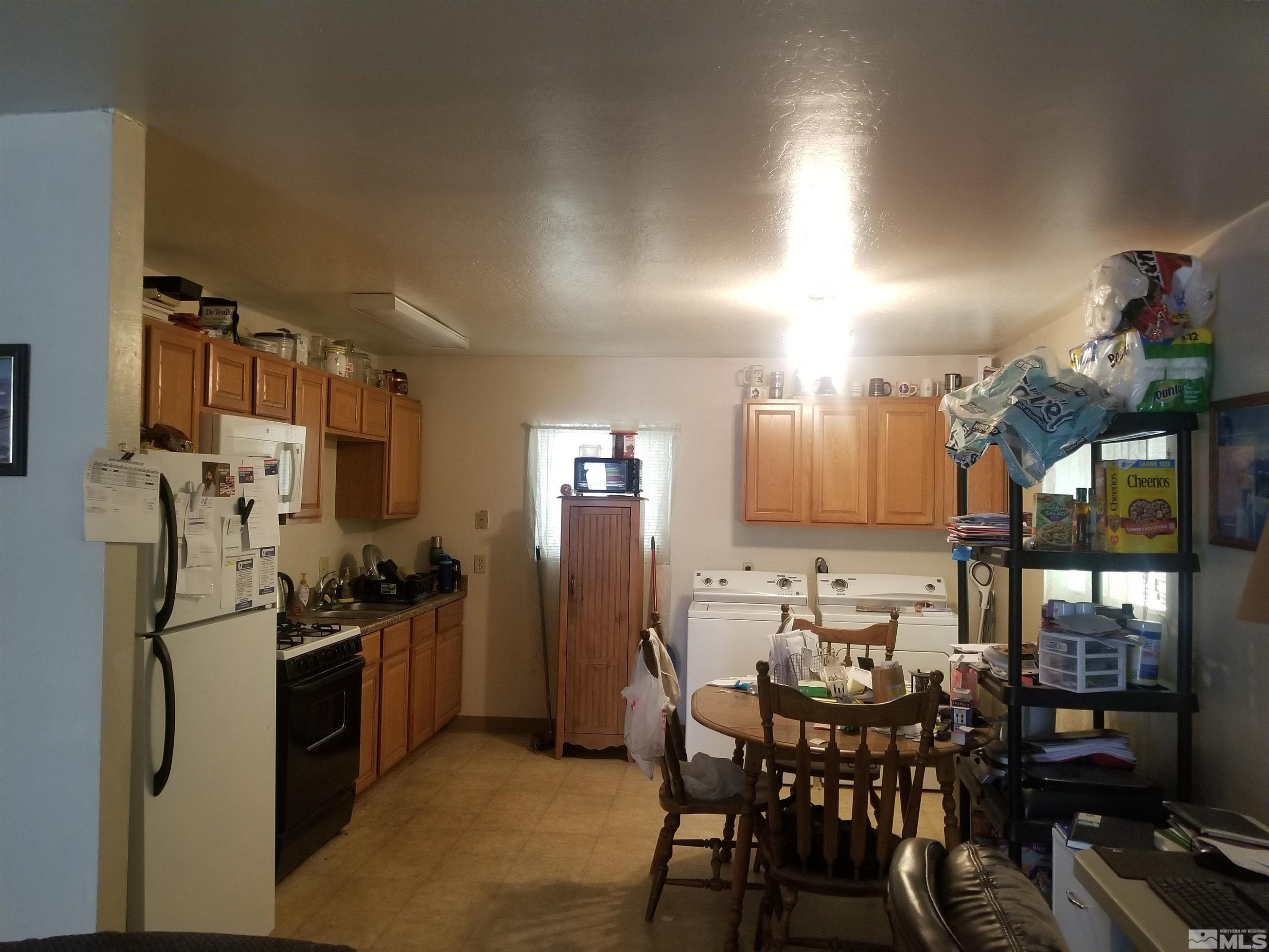 250-252 South Taylor Street Fallon, NV 89406 - Photo 11 of 29 a kitchen with stainless steel appliances kitchen island a table and chairs in it