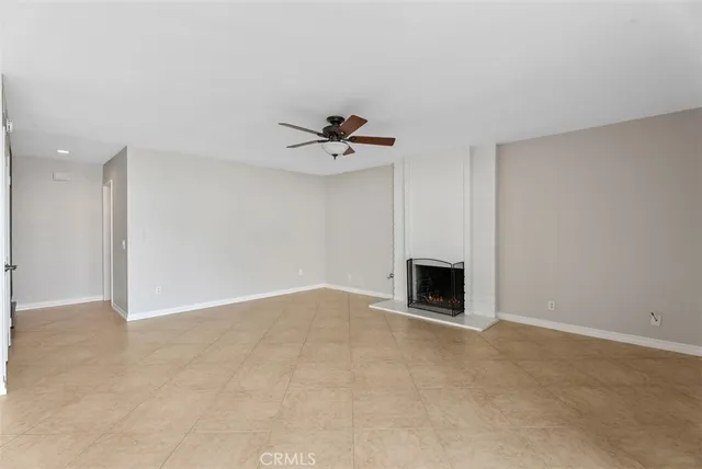a view of a livingroom with a fireplace and a chandelier fan