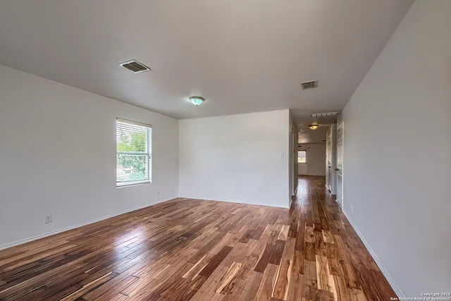 a view of a room with wooden floor and window