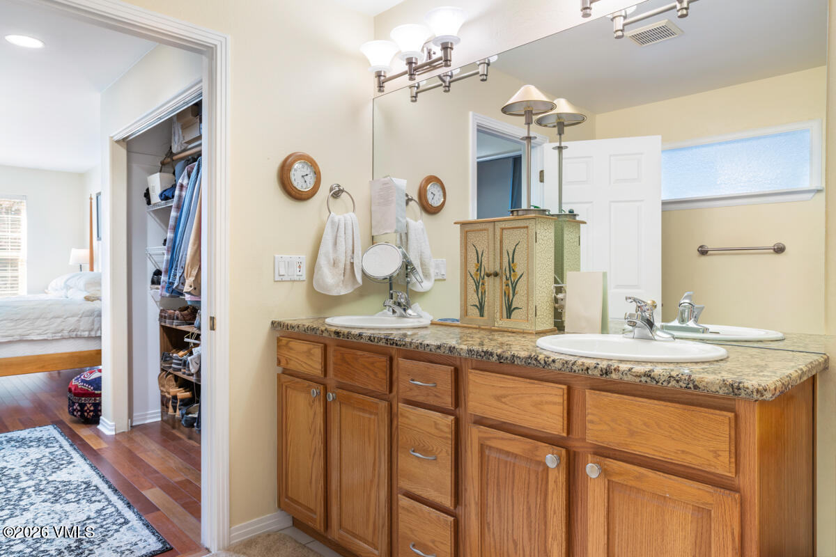 288 Edwards Village Boulevard, Unit 6A Edwards, CO 81632 - Photo 17 of 36 a bathroom with a granite countertop sink and a mirror