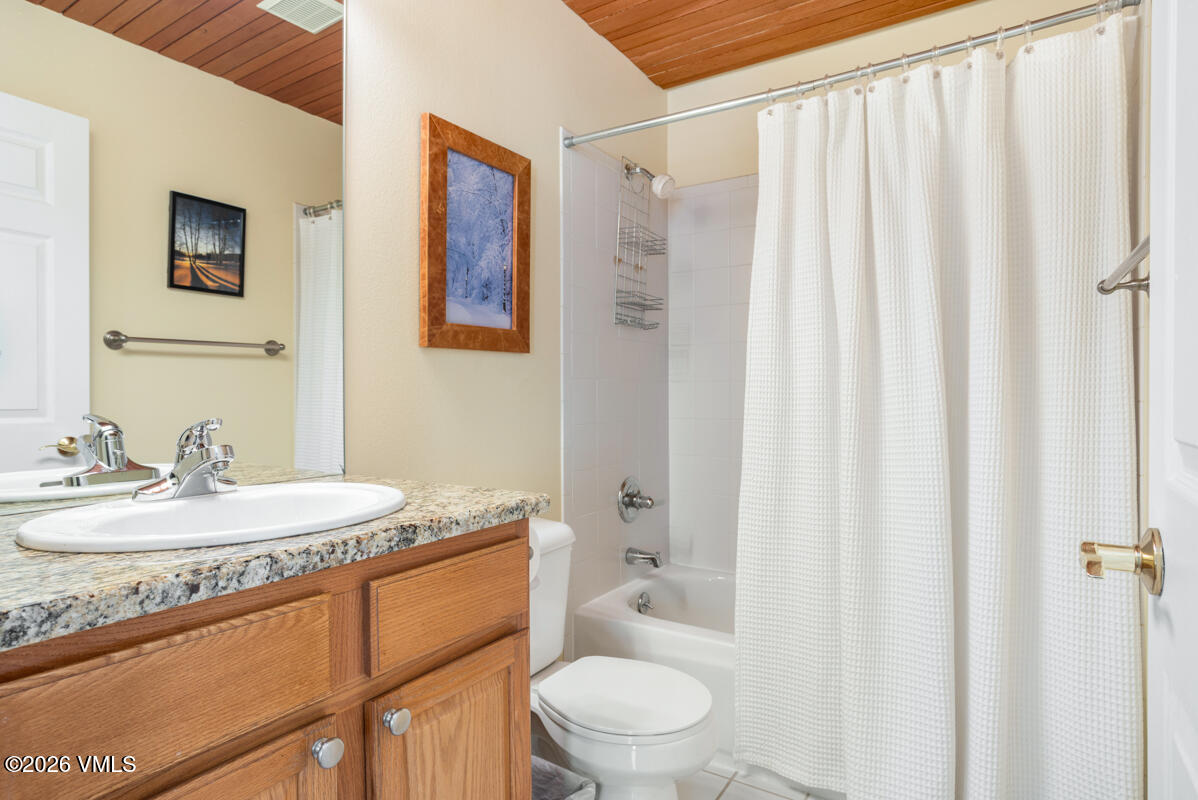 288 Edwards Village Boulevard, Unit 6A Edwards, CO 81632 - Photo 20 of 36 a bathroom with a granite countertop sink a toilet and a mirror
