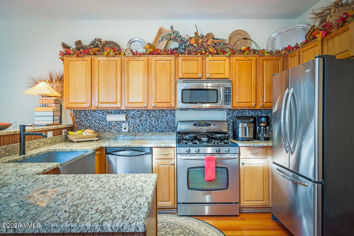 288 Edwards Village Boulevard, Unit 6A Edwards, CO 81632 - Photo 7 of 36 a kitchen with stainless steel appliances granite countertop a sink stove and refrigerator