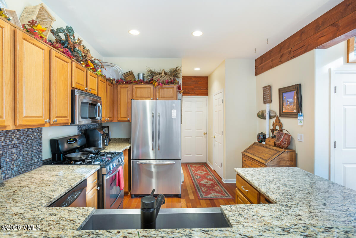 288 Edwards Village Boulevard, Unit 6A Edwards, CO 81632 - Photo 8 of 36 a kitchen with stainless steel appliances granite countertop a refrigerator and a stove