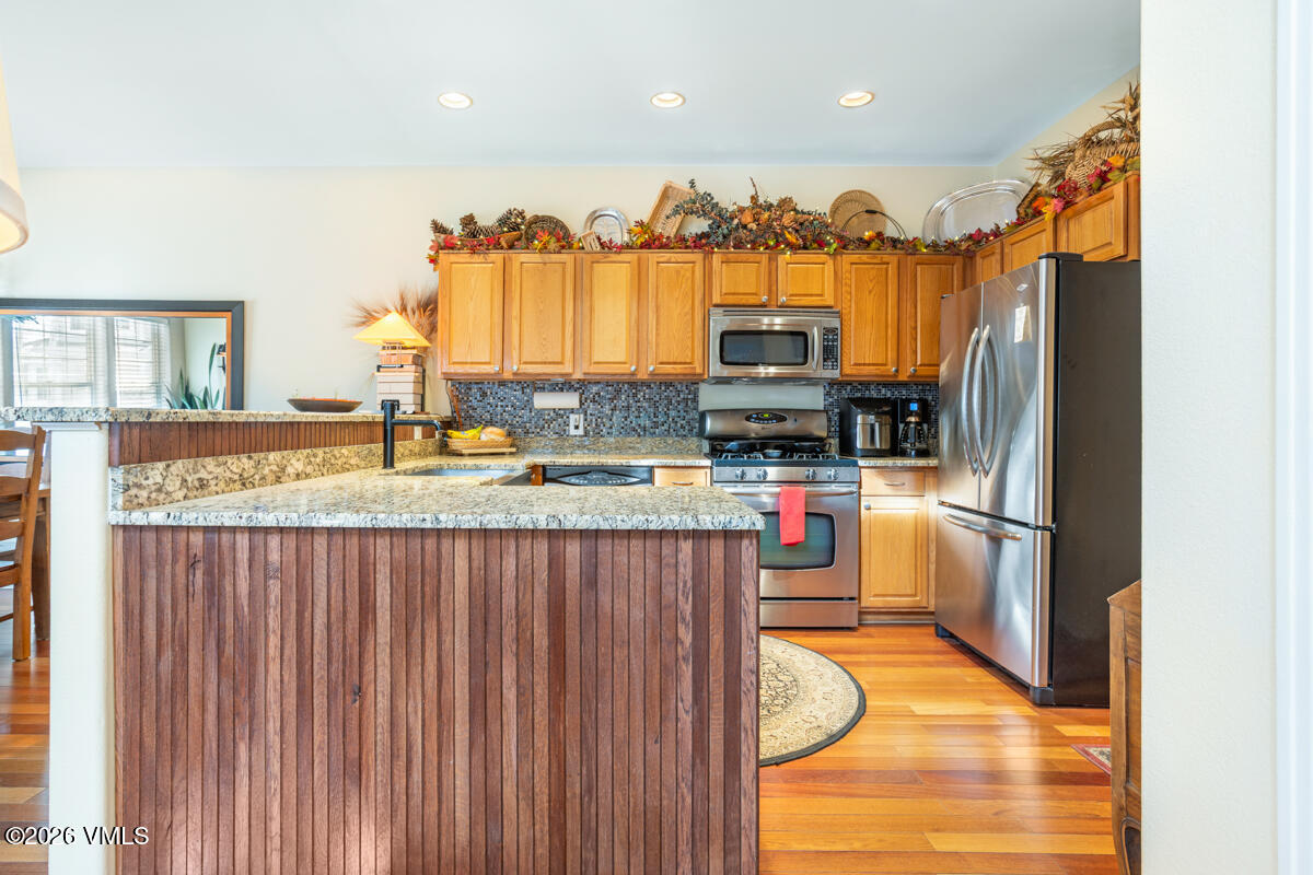 288 Edwards Village Boulevard, Unit 6A Edwards, CO 81632 - Photo 9 of 36 a kitchen with stainless steel appliances granite countertop a refrigerator a stove and a sink