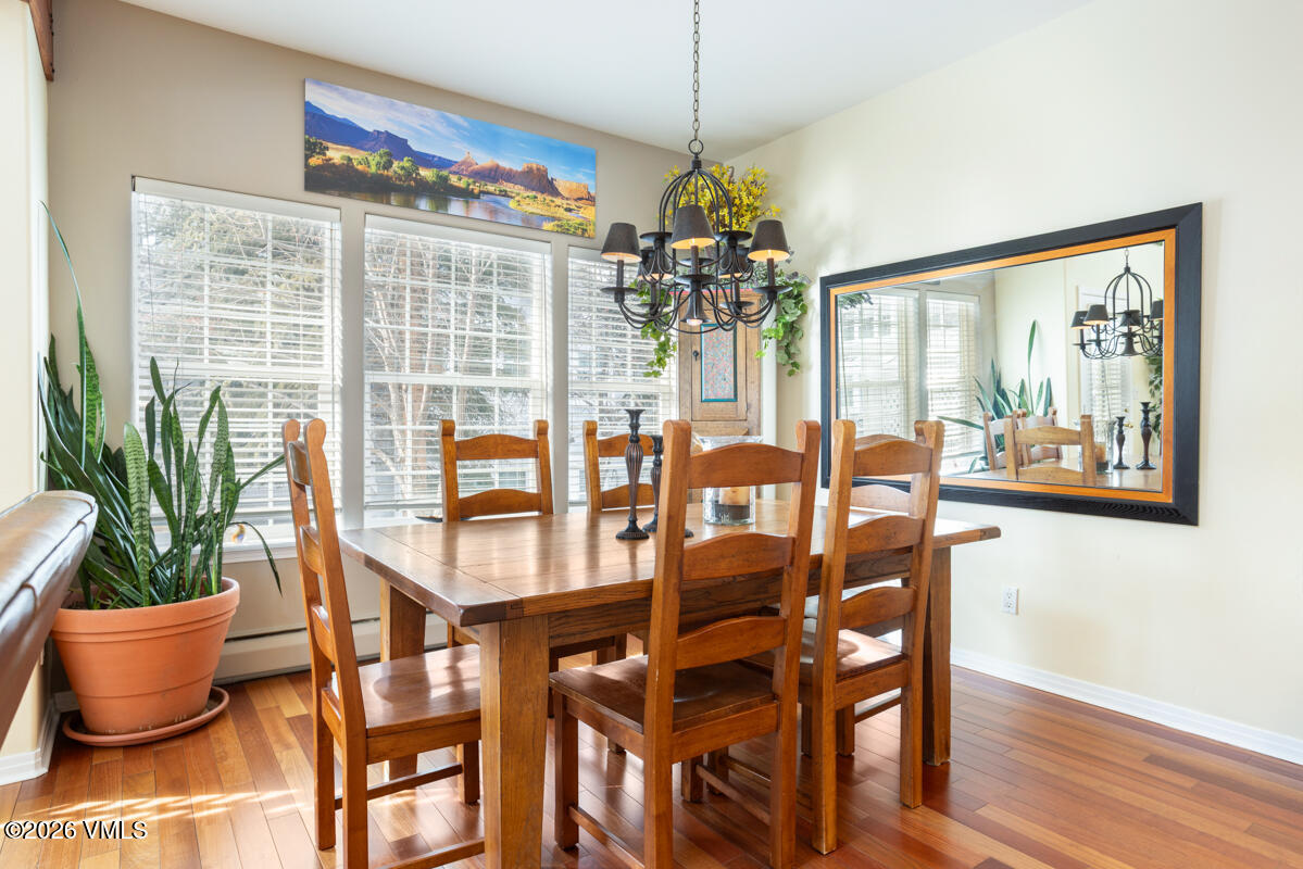 288 Edwards Village Boulevard, Unit 6A Edwards, CO 81632 - Photo 10 of 36 a dining room with furniture a chandelier and wooden floor