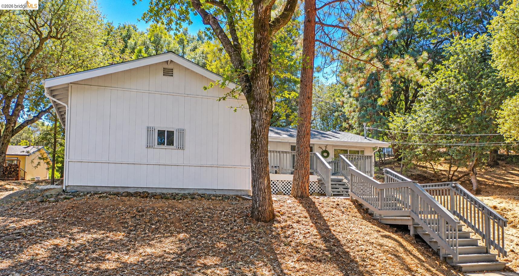 19327 Ferretti Road Groveland, CA 95321 - Photo 2 of 44 Exterior featuring white vertical siding, a gray shingle roof, and a front deck with gray painted stairs and railing
