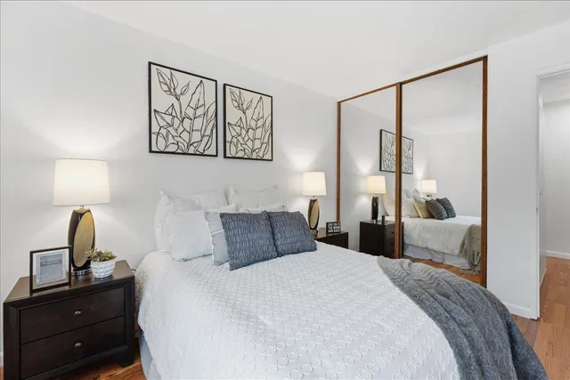 a bedroom with a bed and a lamp on dresser