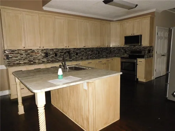 a kitchen with stainless steel appliances granite countertop a sink a stove and a refrigerator