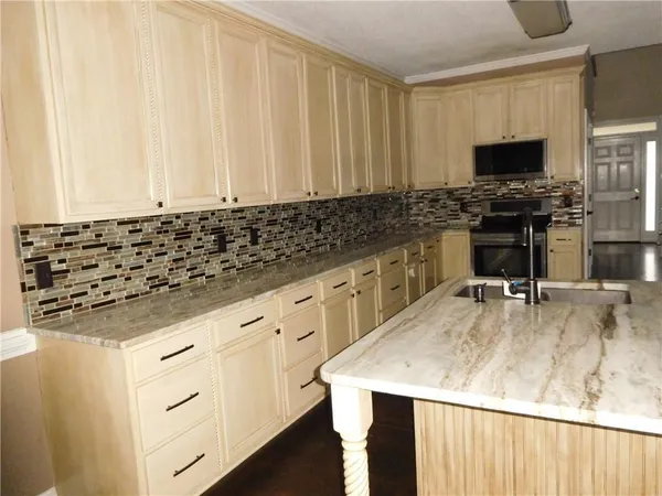 a kitchen with granite countertop a sink a stove and a microwave