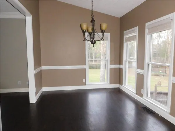 a view of a room with wooden floor and windows