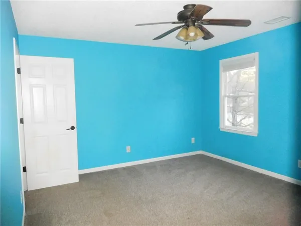 a view of a livingroom with a ceiling fan & cabinetry