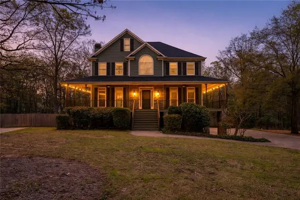 a view of a house with backyard and trees