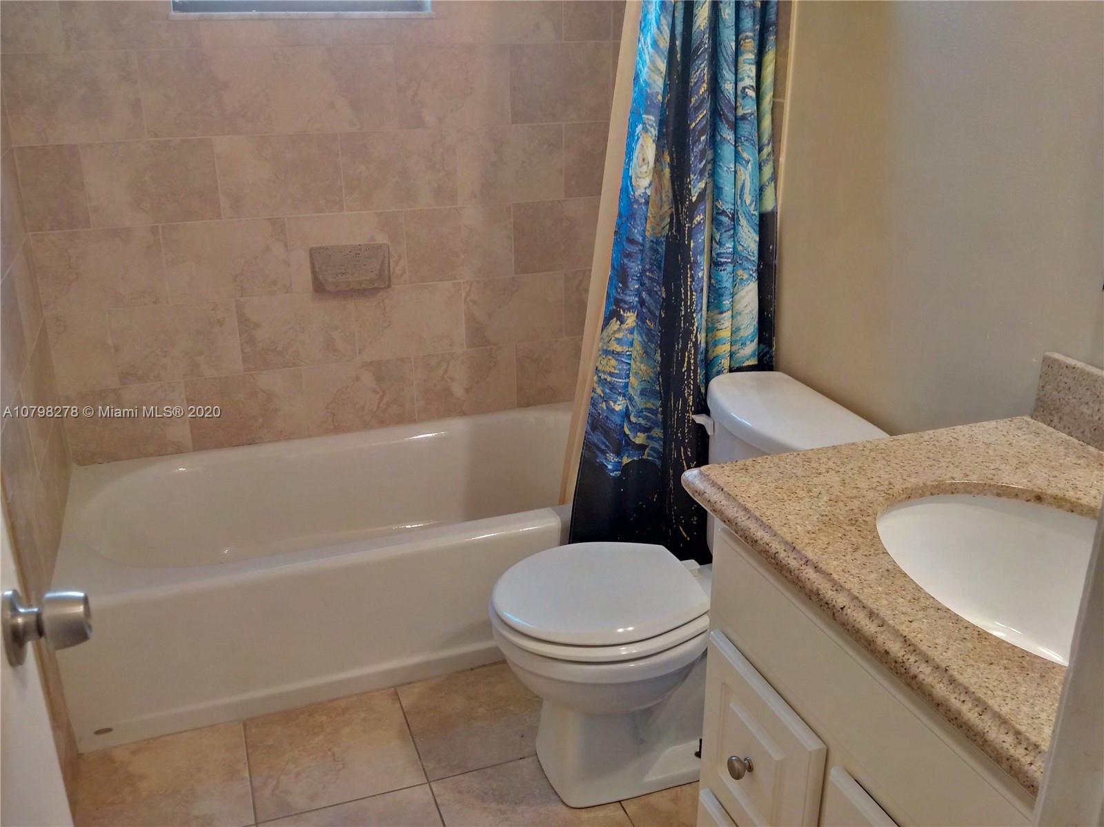 13060 Southwest 263rd Terrace Homestead, FL 33032 - Photo 11 of 28 a white toilet sitting next to a bath tub