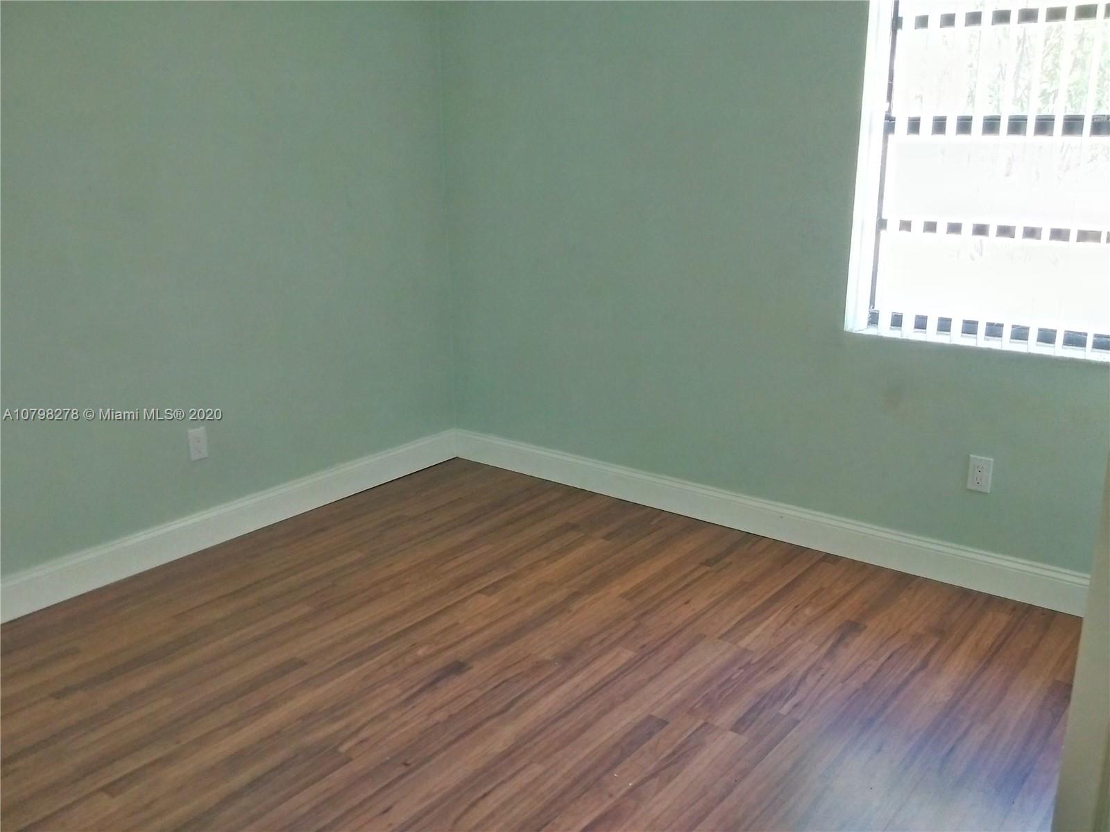 13060 Southwest 263rd Terrace Homestead, FL 33032 - Photo 19 of 28 an empty room with wooden floor and windows