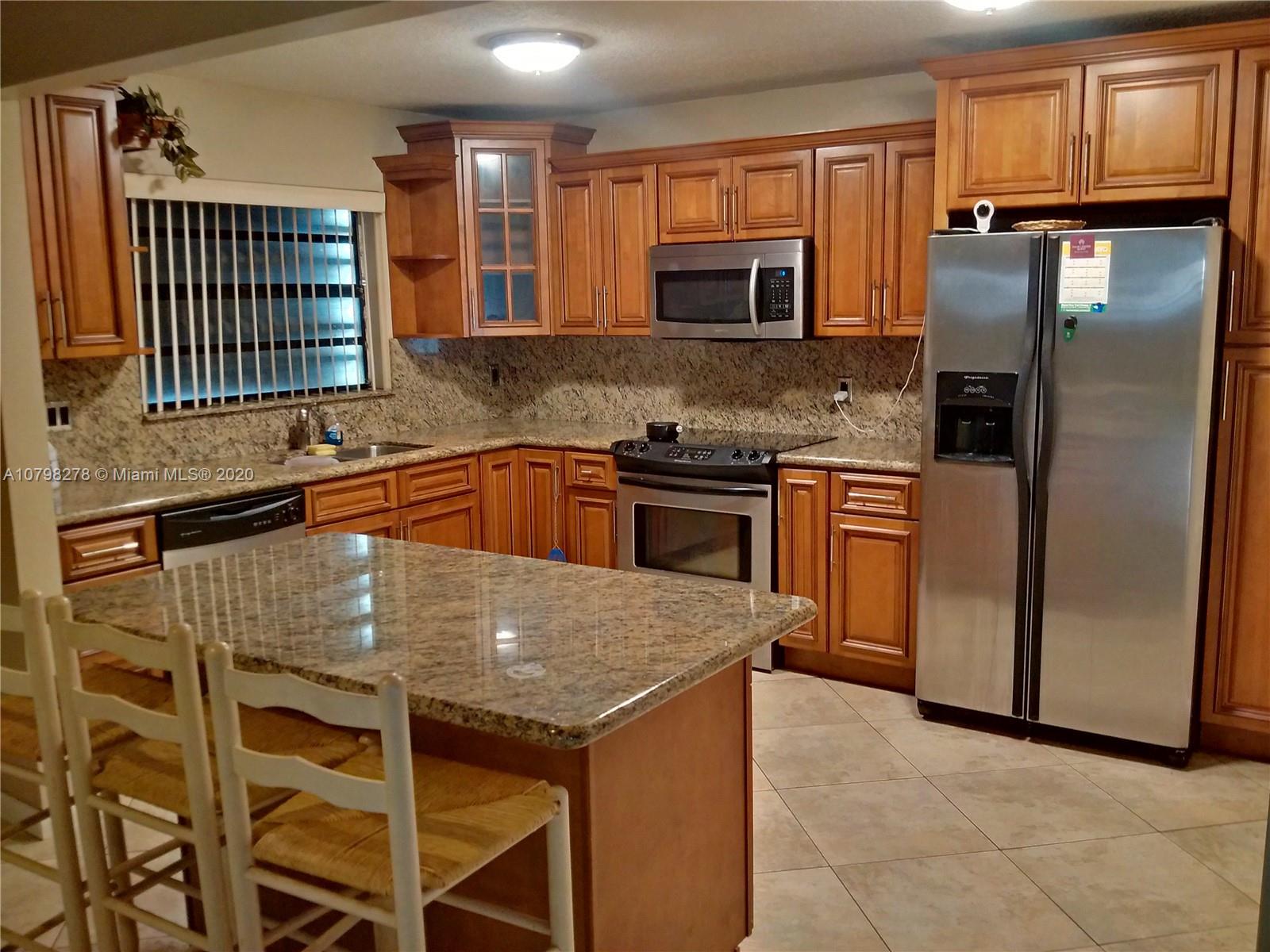 13060 Southwest 263rd Terrace Homestead, FL 33032 - Photo 2 of 28 a kitchen with granite countertop stainless steel appliances a sink and a counter space