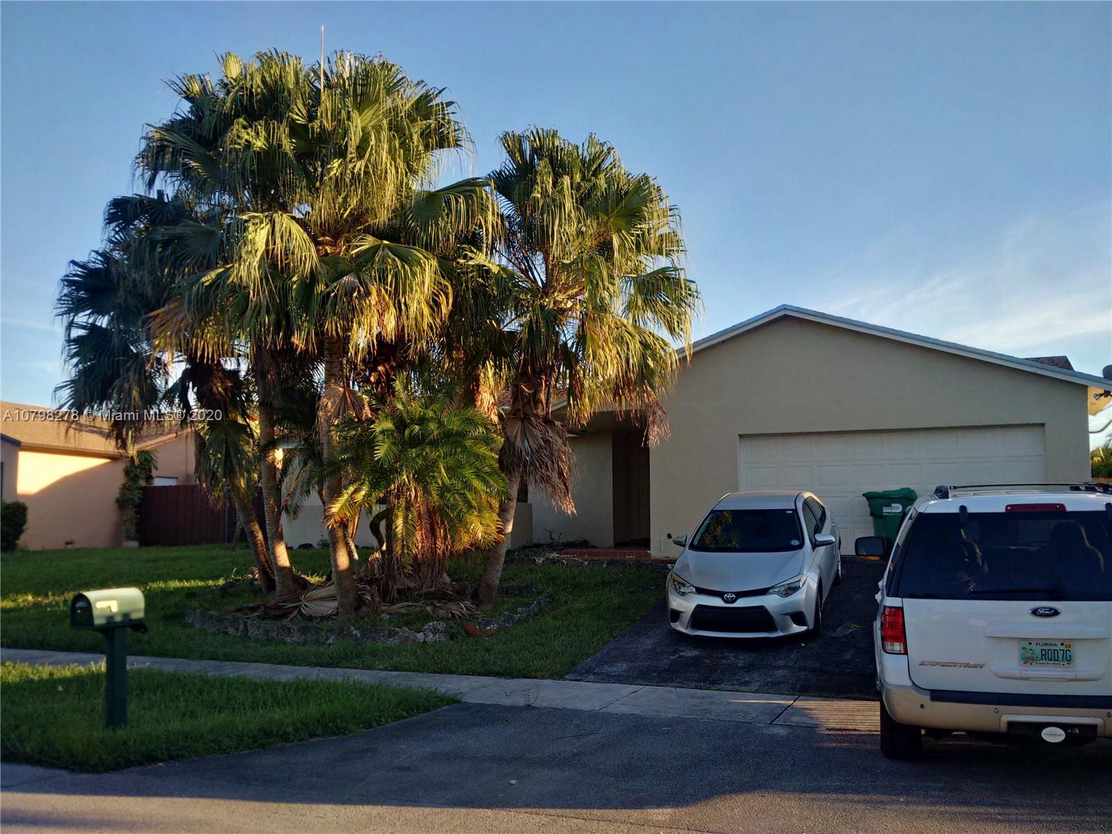 13060 Southwest 263rd Terrace Homestead, FL 33032 - Photo 28 of 28 a car parked in front of a house with wooden fence