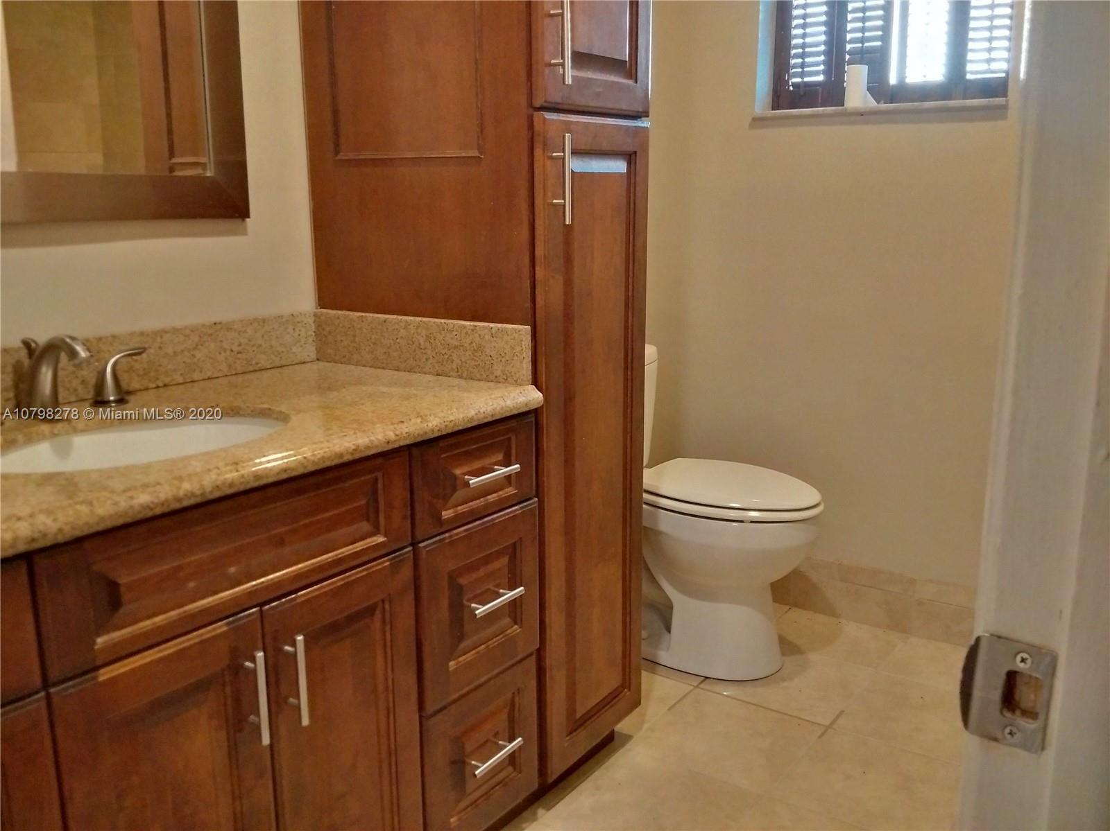 13060 Southwest 263rd Terrace Homestead, FL 33032 - Photo 7 of 28 a bathroom with a granite countertop toilet sink and mirror