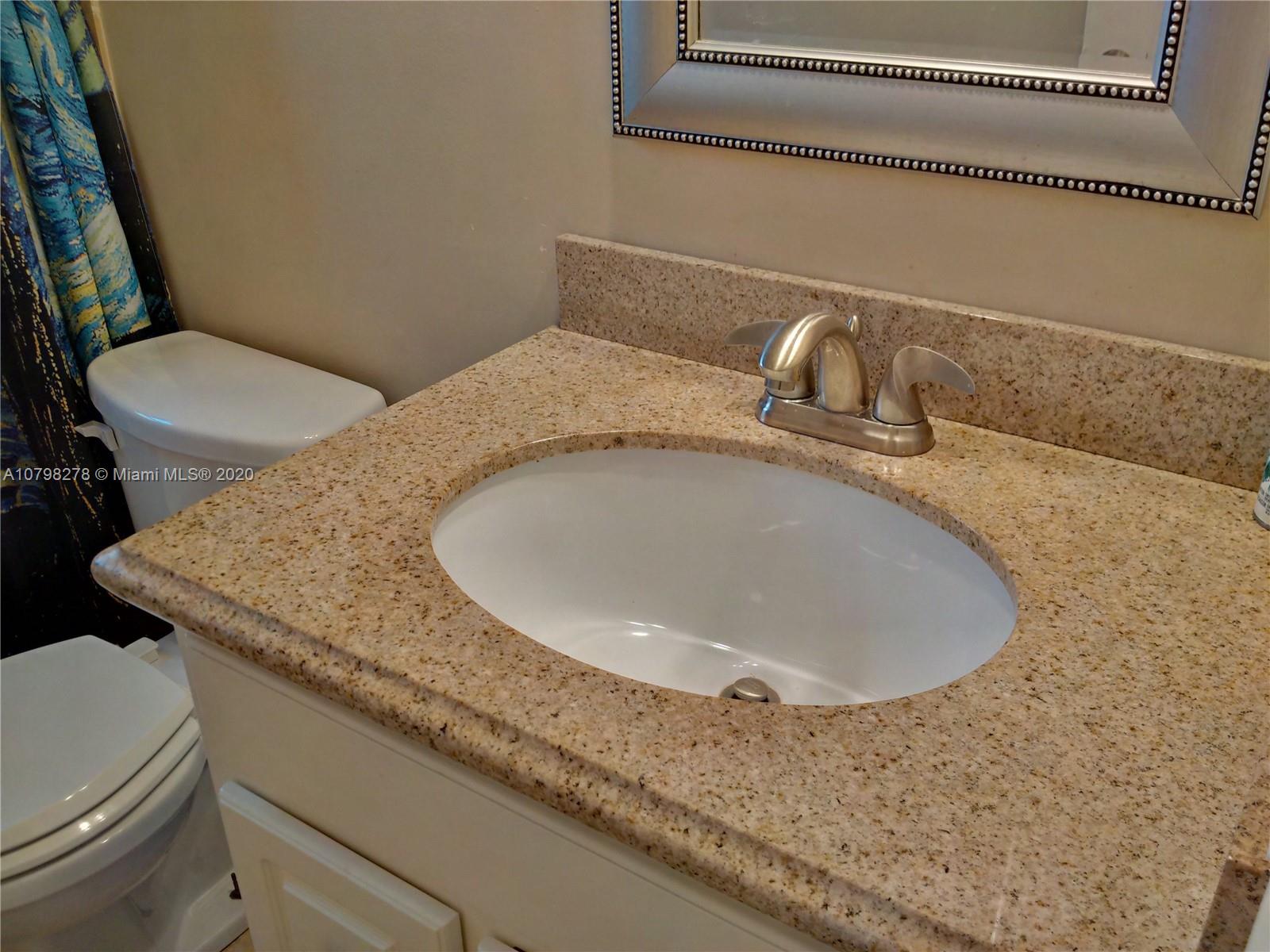 13060 Southwest 263rd Terrace Homestead, FL 33032 - Photo 10 of 28 a bathroom with a granite countertop sink a toilet and a mirror