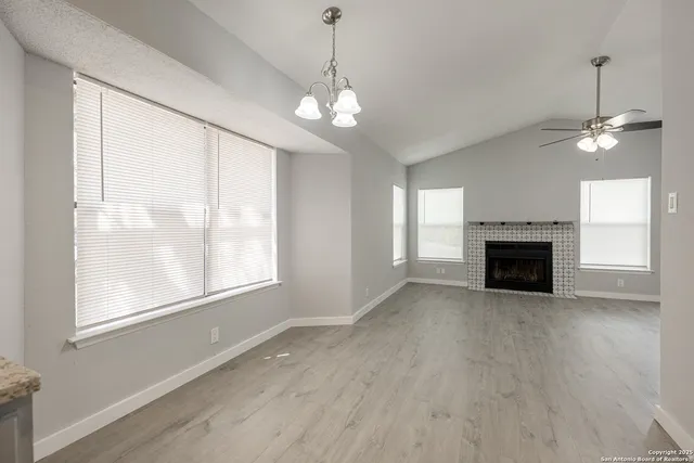 a view of an empty room with a window and fireplace