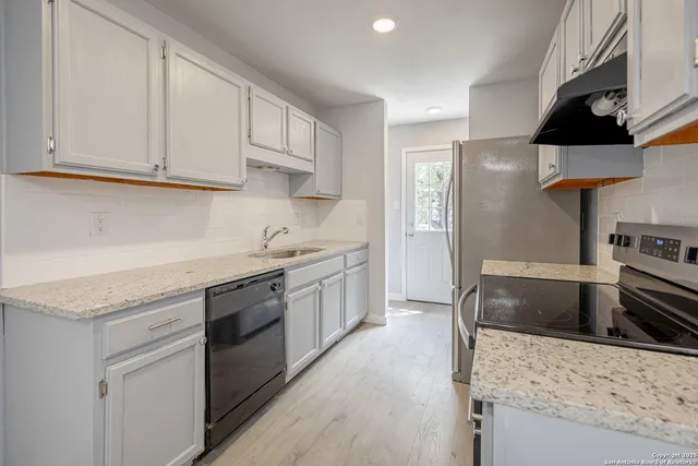 a kitchen with stainless steel appliances granite countertop a sink stove and refrigerator