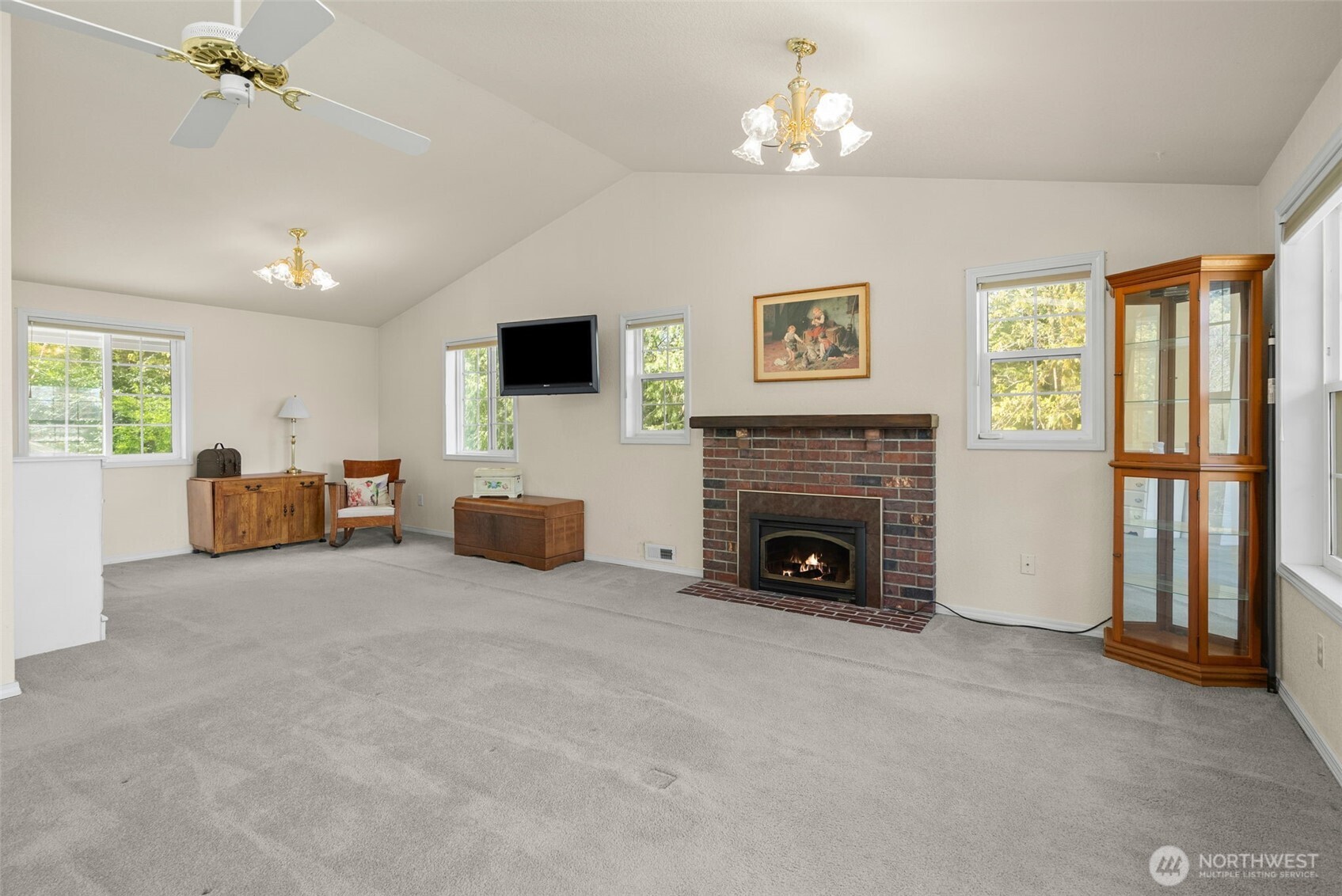 8320 East Grapeview Loop Road Allyn, WA 98524 - Photo 19 of 38 a living room with furniture a fireplace and a flat screen tv