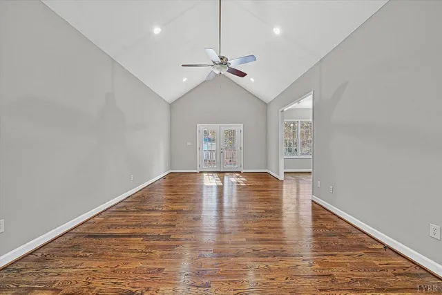 a view of empty room with wooden floor and ceiling fan