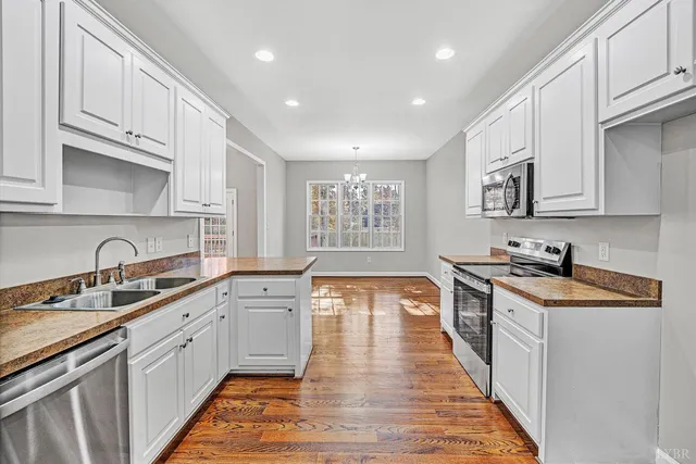 a kitchen with stainless steel appliances granite countertop a sink stove and cabinets