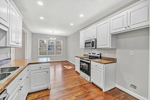 a kitchen with granite countertop white cabinets and appliances