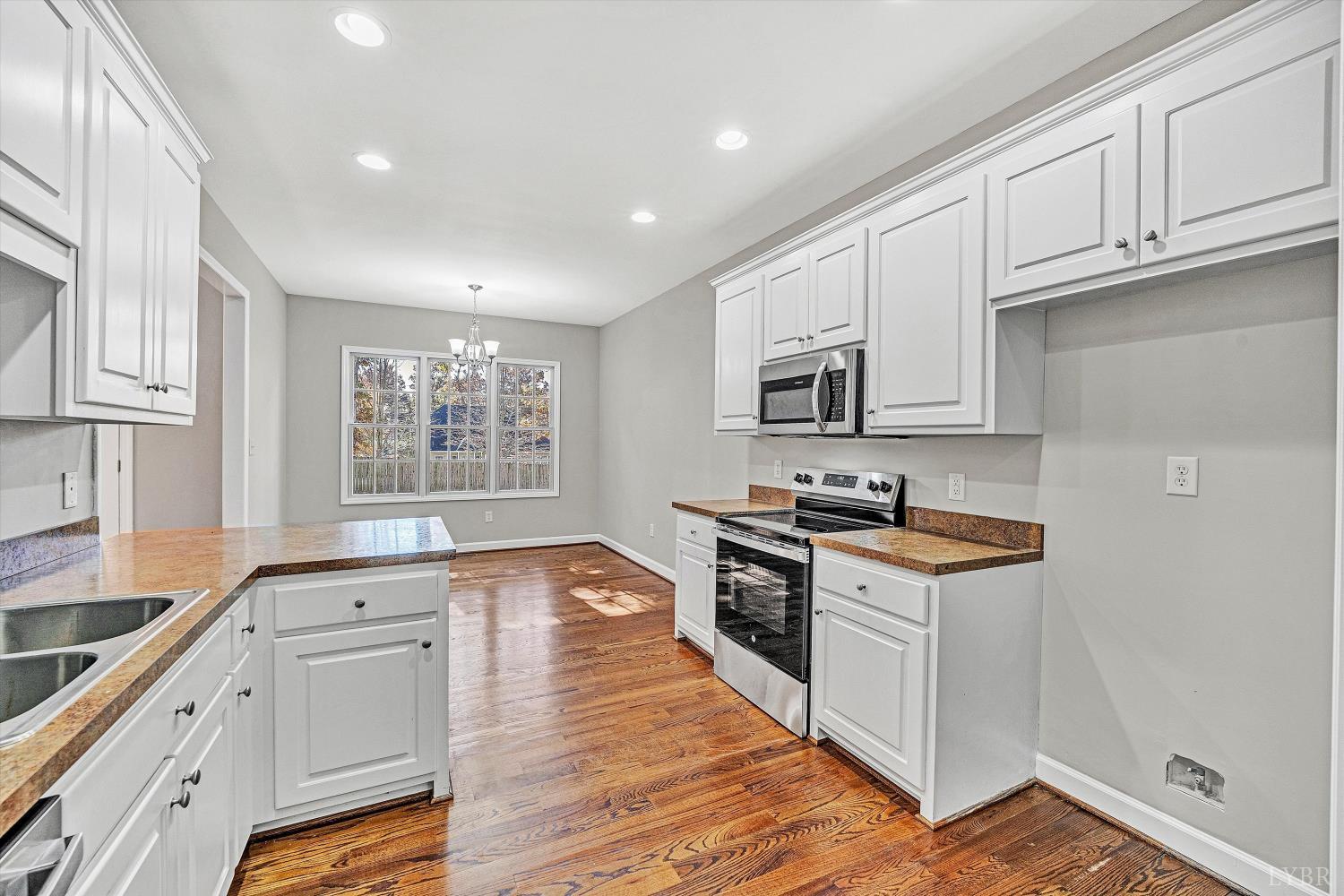1182 Dan River Church Road South Boston, VA 24592 - Photo 17 of 43 a kitchen with granite countertop white cabinets and appliances