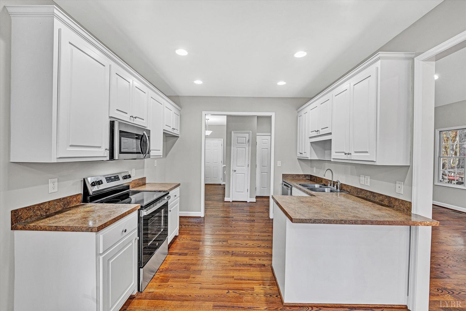 1182 Dan River Church Road South Boston, VA 24592 - Photo 19 of 43 a kitchen with granite countertop stainless steel appliances a sink a stove top oven a counter space and cabinets
