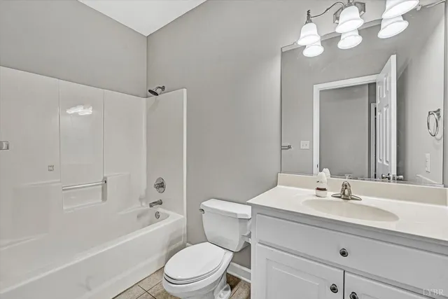 a bathroom with a sink a toilet a mirror a vanity and bathtub