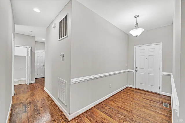 a view of a hallway with wooden floor and staircase