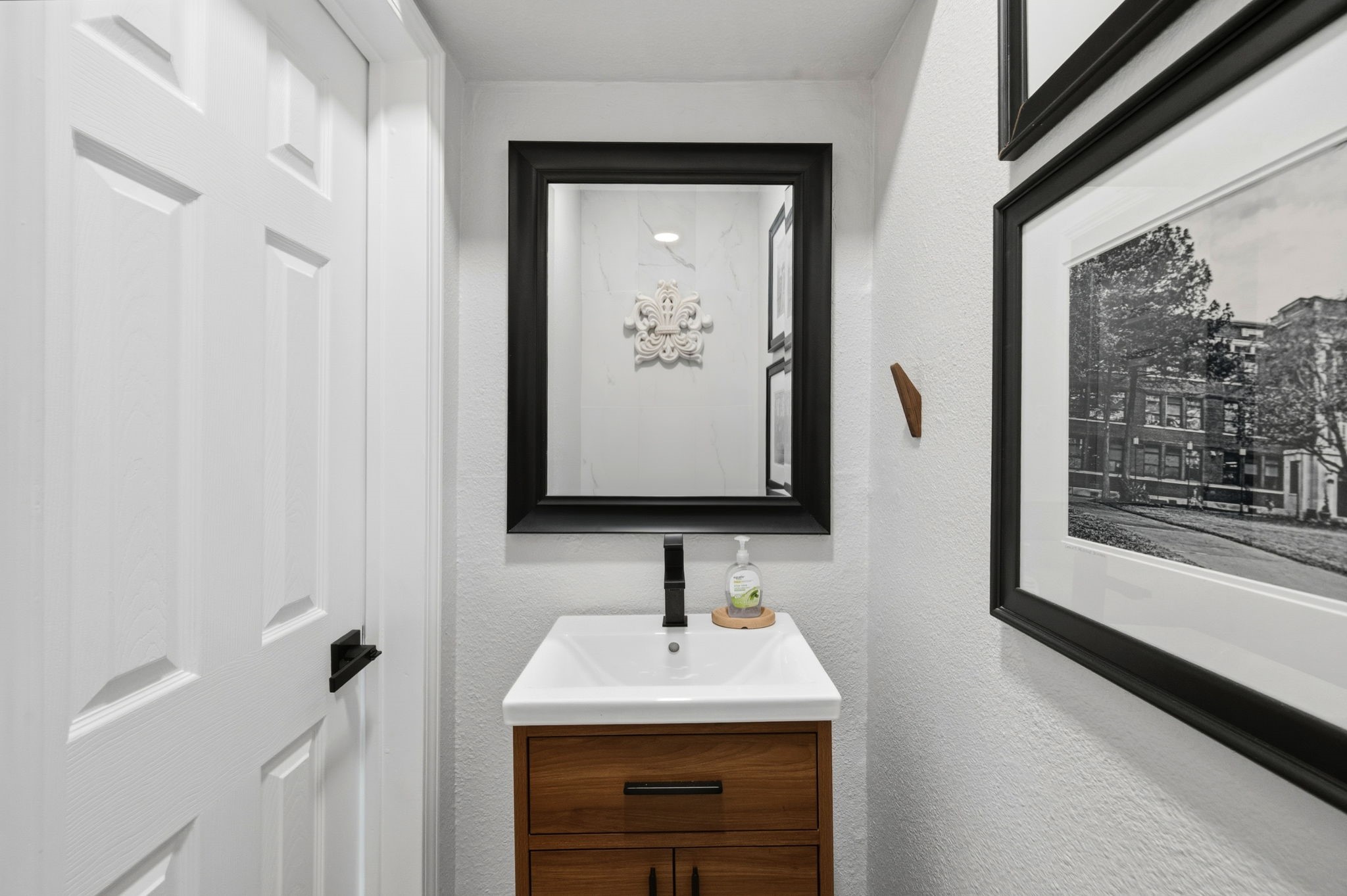 1831 Palm Street Houston, TX 77004 - Photo 11 of 27 First floor modern half-bathroom with a sleek white sink atop a wooden vanity.