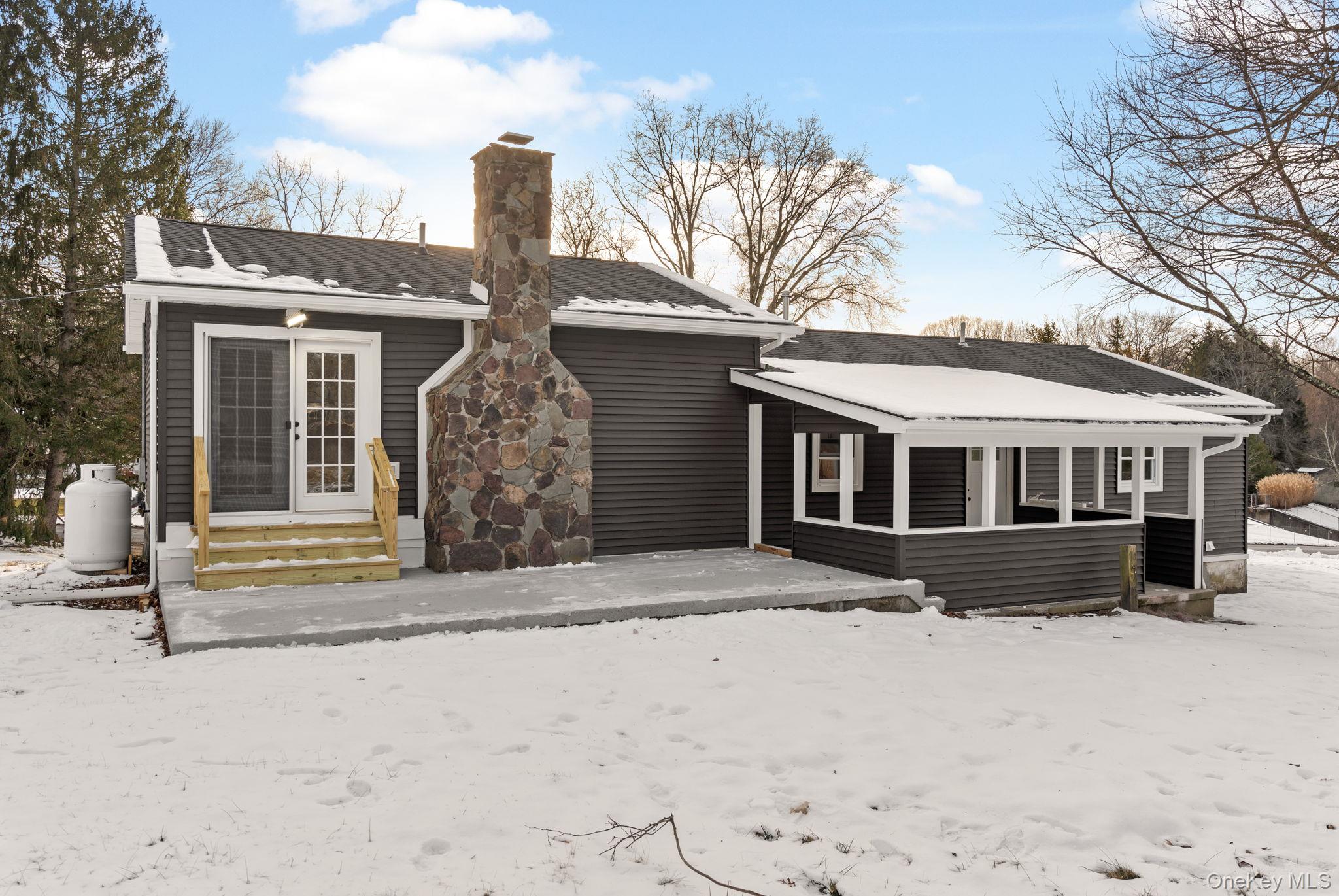 52 Rudolph Road Modena, NY 12548 - Photo 37 of 49 Snow covered back of property featuring a patio area, entry steps, a chimney, and roof with shingles