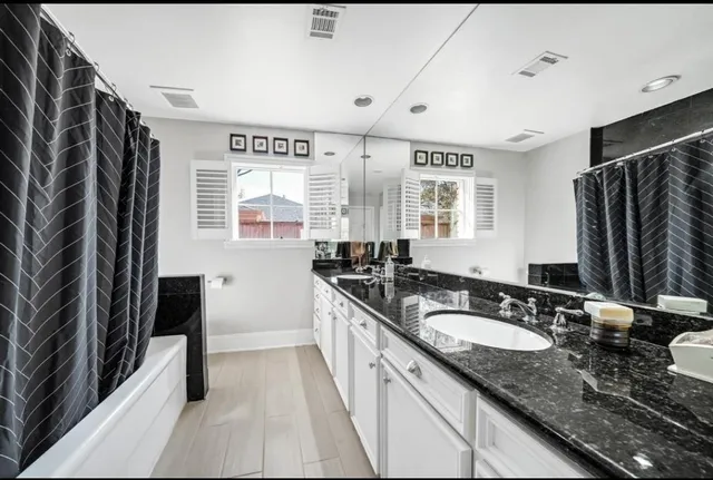 a bathroom with double vanity and a mirror