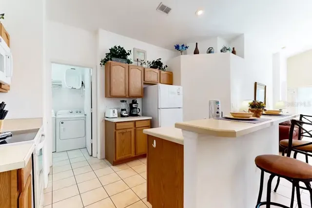 a kitchen with white cabinets and appliances