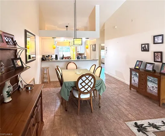 a dining room with furniture a floor to ceiling window and wooden floor
