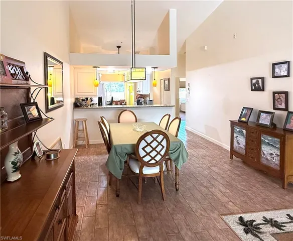 a dining room with furniture a floor to ceiling window and wooden floor