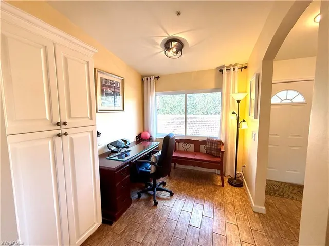 a view of a workspace with furniture and a window